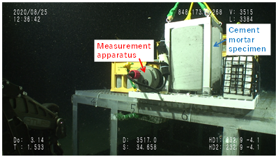  Measurement apparatus next to cement mortar specimen at a water depth of approximately 3,500 meters (Copyrighted image courtesy of JAMSTEC)